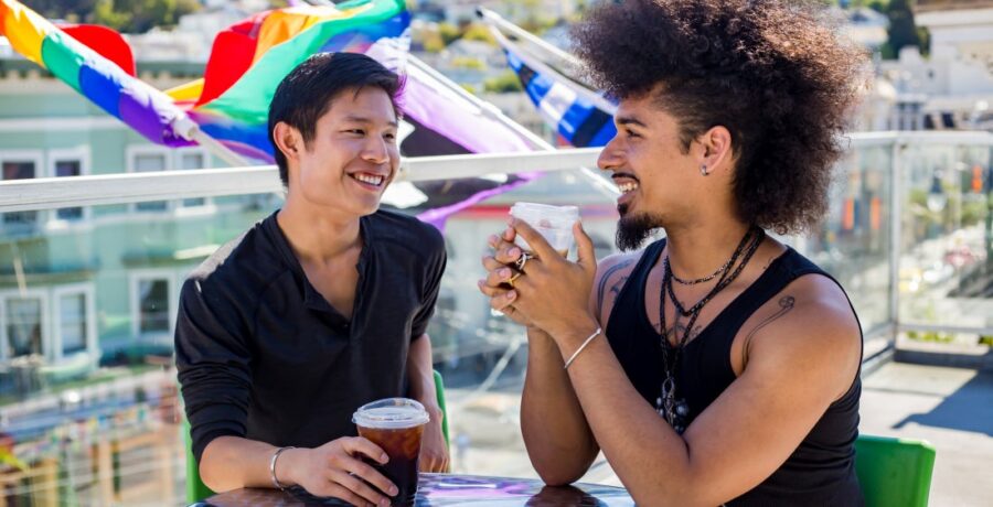 Two people sitting drinking coffee on patio at SFAF health center Strut