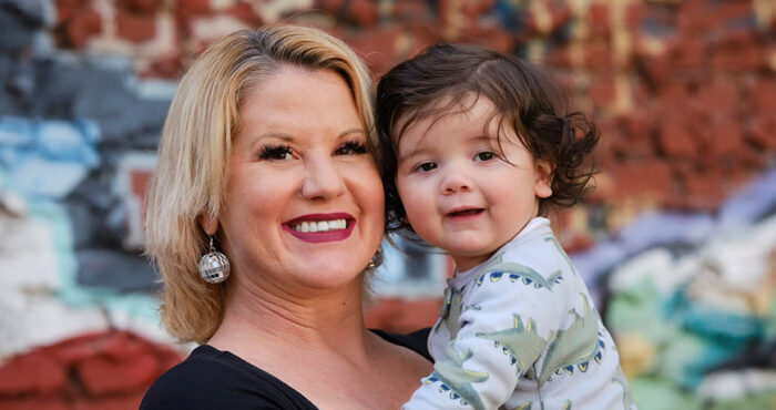 Chelsea, a PROP client, faces the camera smiling and holding her baby