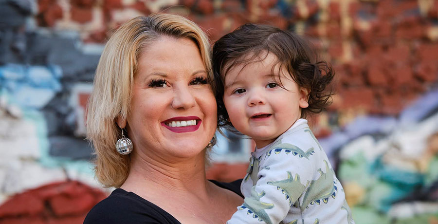 Chelsea, a PROP client, faces the camera smiling and holding her baby