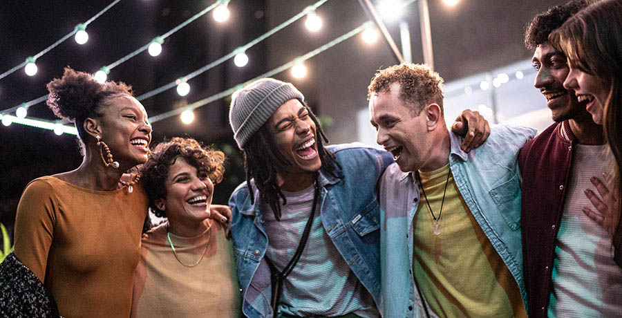 Friends embracing having fun in the street at night