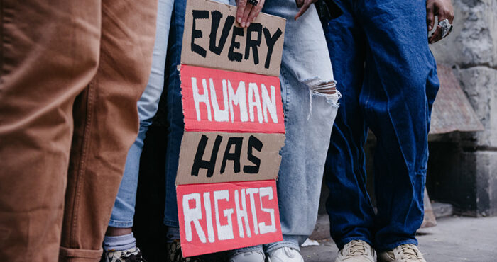 Group of people holding a sign "Every Human Has Rights"